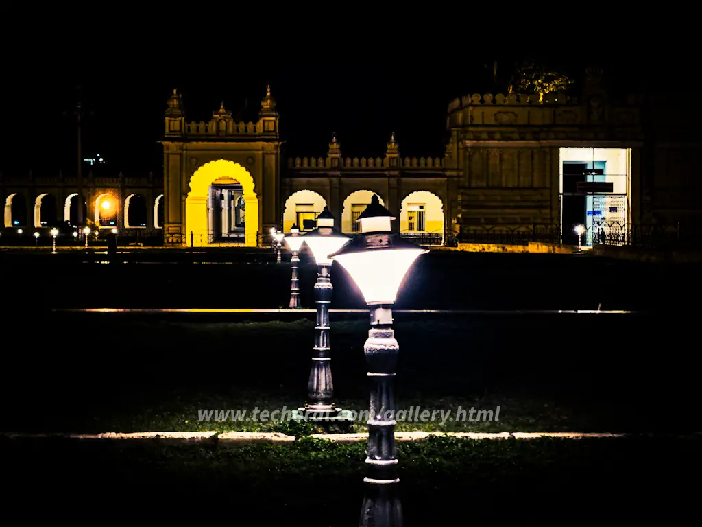 Radiant night view of Mysore Palace and its surrounding gardens, illuminated under the starry sky. The palace lights cast a magical glow, accentuating the architectural marvels, while the lush greenery of the garden adds a serene backdrop. Experience the captivating beauty of Mysore Palace and its enchanting gardens, a harmonious blend of history and natural splendor, in this mesmerizing image.